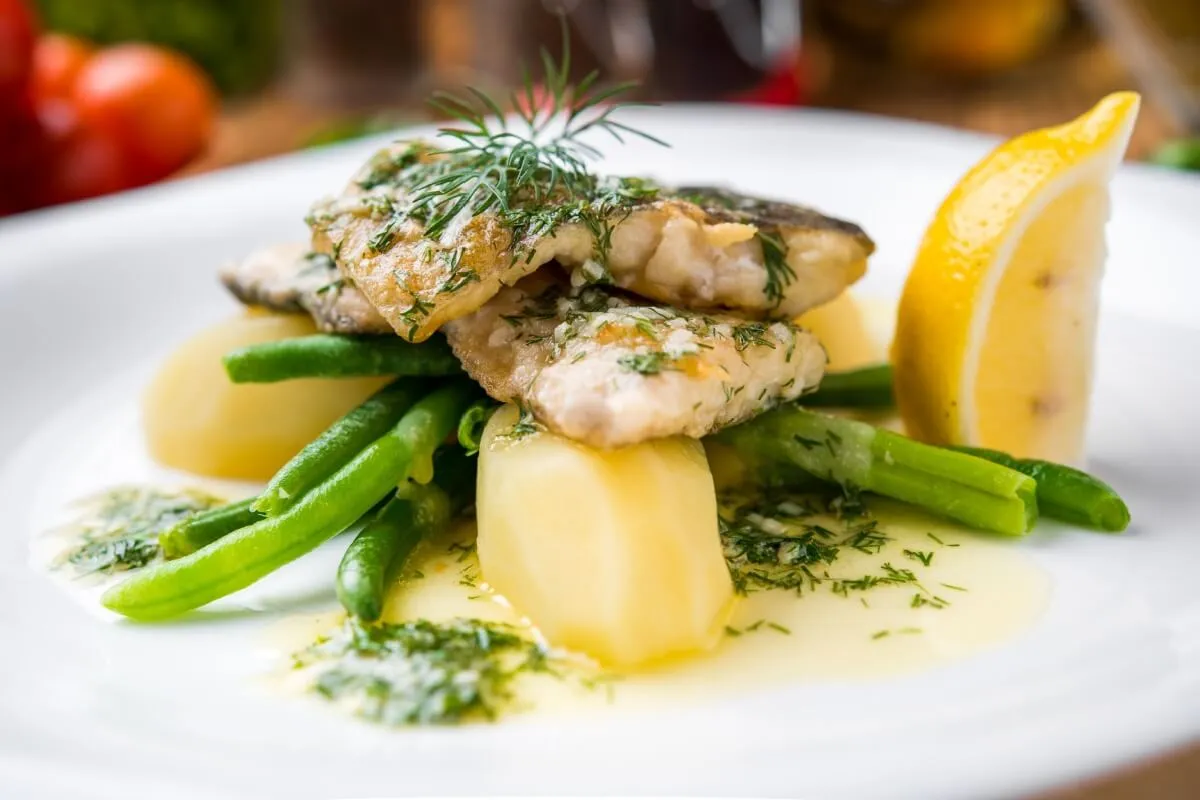 Peixe com batata, vagem e molho de limão (Imagem: WhiteYura | Shutterstock)