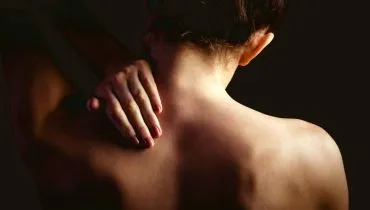 Imagem mostra uma mulher com dor nas costas.