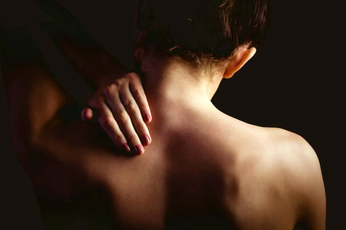 Imagem mostra uma mulher com dor nas costas.