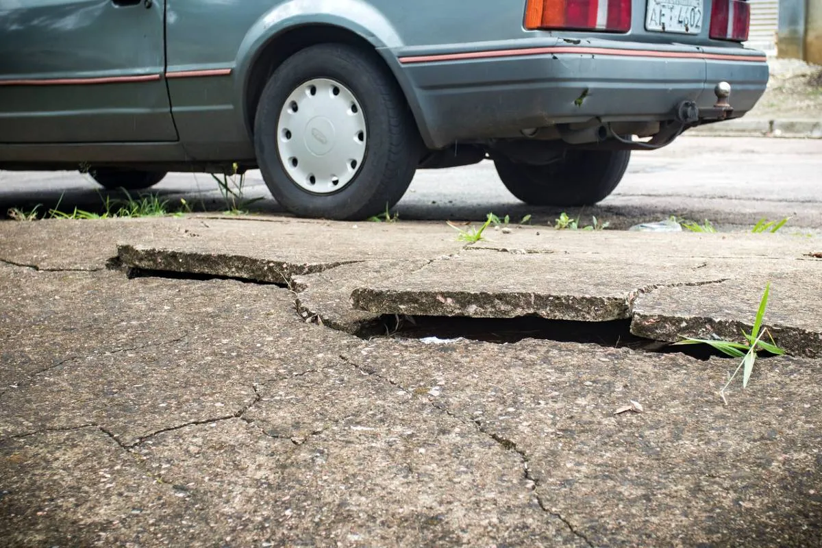 Imagem mostra a Calçada e asfalto cedendo na Rua Joanna Emma Dalpozzo Zardo em Santa Felicidade, às margens do Rio Cascatinha