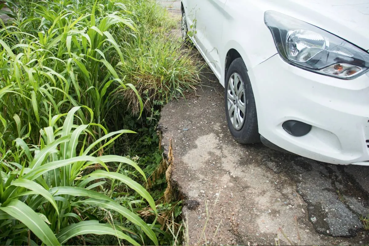 Imagem mostra a Calçada e asfalto cedendo na Rua Joanna Emma Dalpozzo Zardo em Santa Felicidade, às margens do Rio Cascatinha