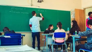 Imagem mostra um professor dando aula em uma escola pública no Paraná.