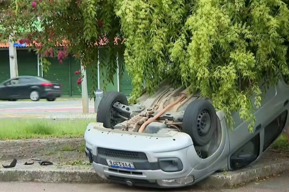 Imagem mostra um carro capotado após um acidente em Curitiba.