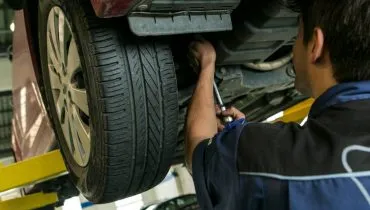 Imagem mostra um mecânico trabalhando em um carro.