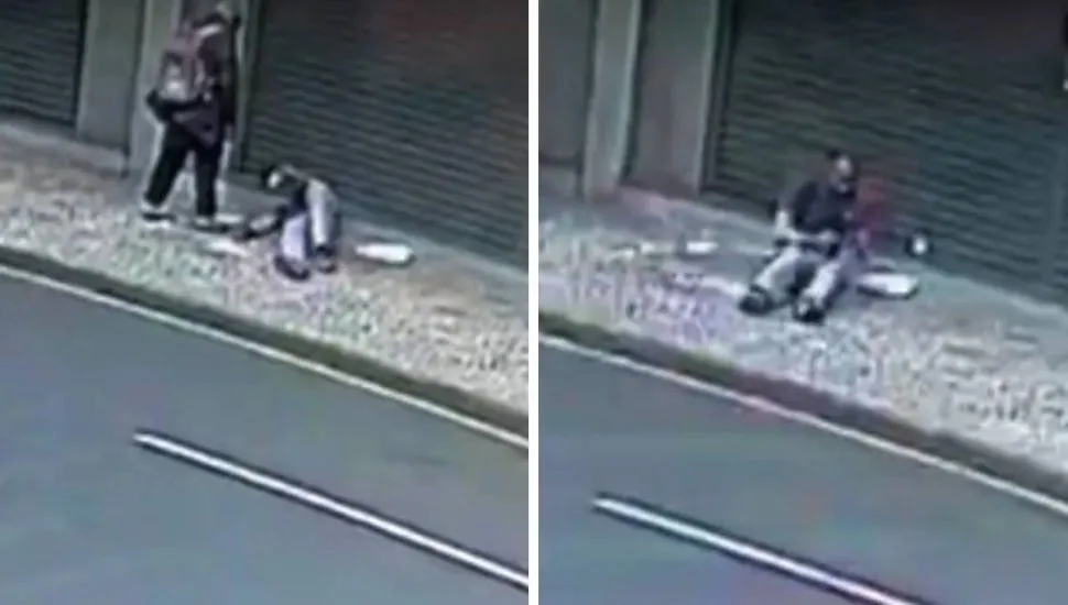 Após a ação, o agressor se afasta. Em poucos segundos, o homem incendiado se debate para tentar apagar as chamas.