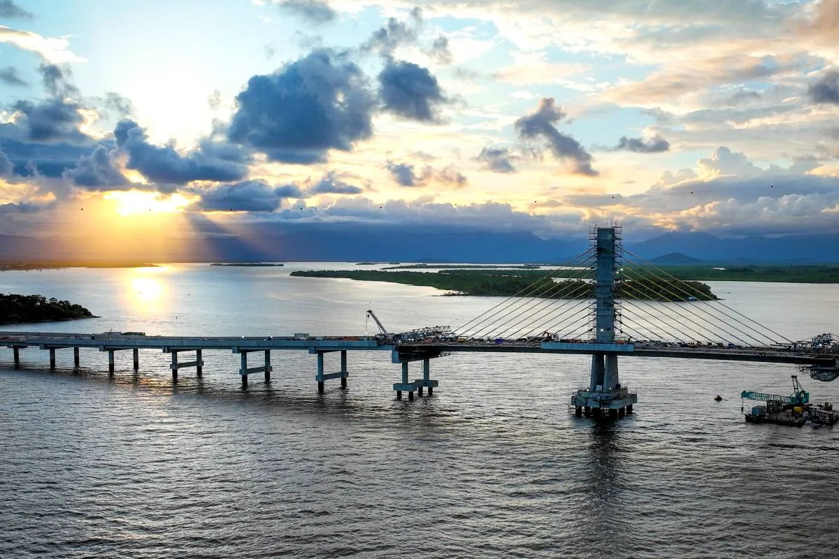 Imagem mostra a obra da Ponte de Guaratuba com um belo por do sol ao fundo.