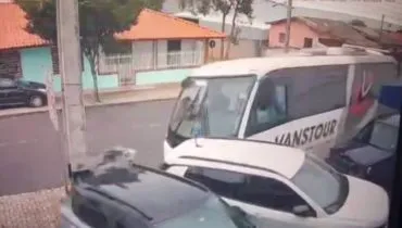 Imagem de câmera de segurança mostra o momento de um acidente em São José dos Pinhais. A imagem tem um ônibus desgovernado atingindo 2 carros e um poste.