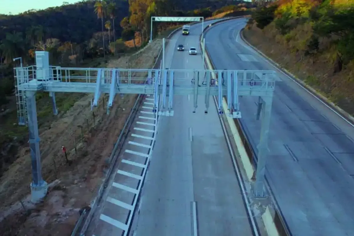 Imagem mostra uma praça de pedágio sem cabine de cobrança no meio de uma estrada.