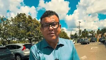 imagem mostra deputado gravando um vídeo em um estacionamento