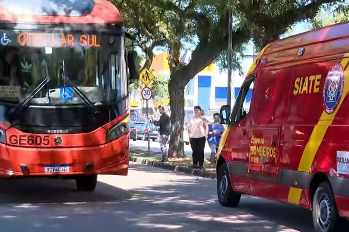 Imagem mostra um ônibus vermelho ao lado de uma viatura dos bombeiros