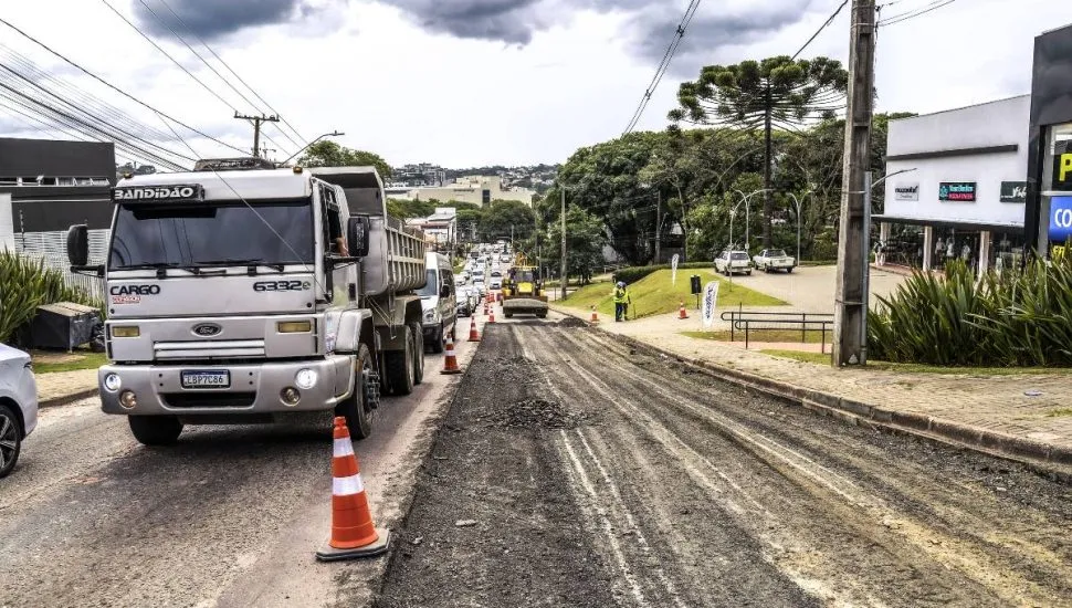 Imagem mostra máquinas trabalhando em uma rua para aplicação de novo asfalto.