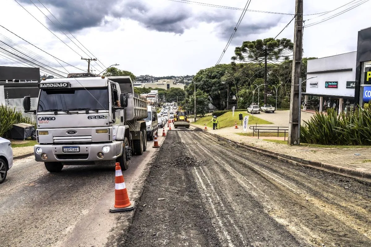 Imagem mostra máquinas trabalhando em uma rua para aplicação de novo asfalto.