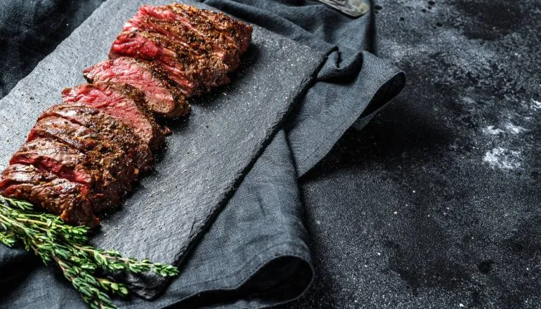 Imagem mostra uma tábua de carne com uma peça cortada em cima.
