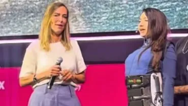 Imagem mostra Lais Souza em pé, com a ajuda de uma ortese, ao lado da Dra Tatiana Sampaio.