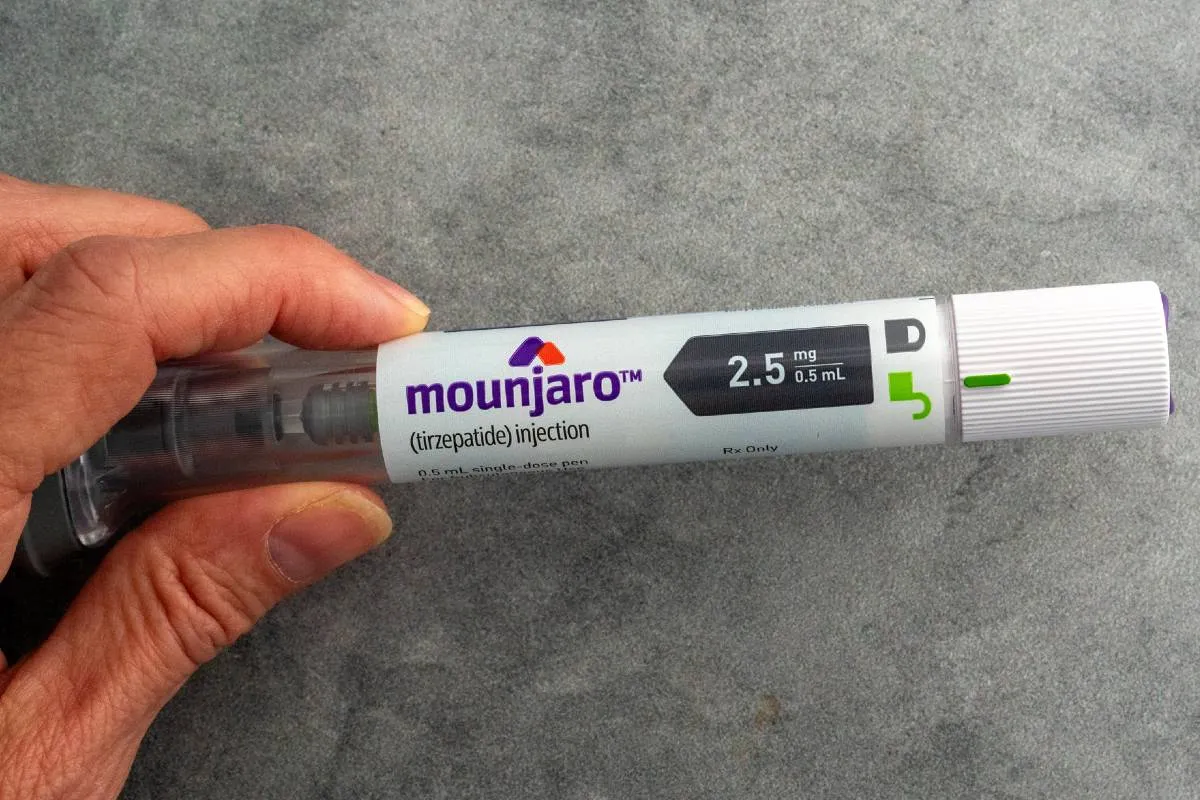 Imagem mostra uma pessoa segurando uma caneta emagrecedora da Mounjaro.