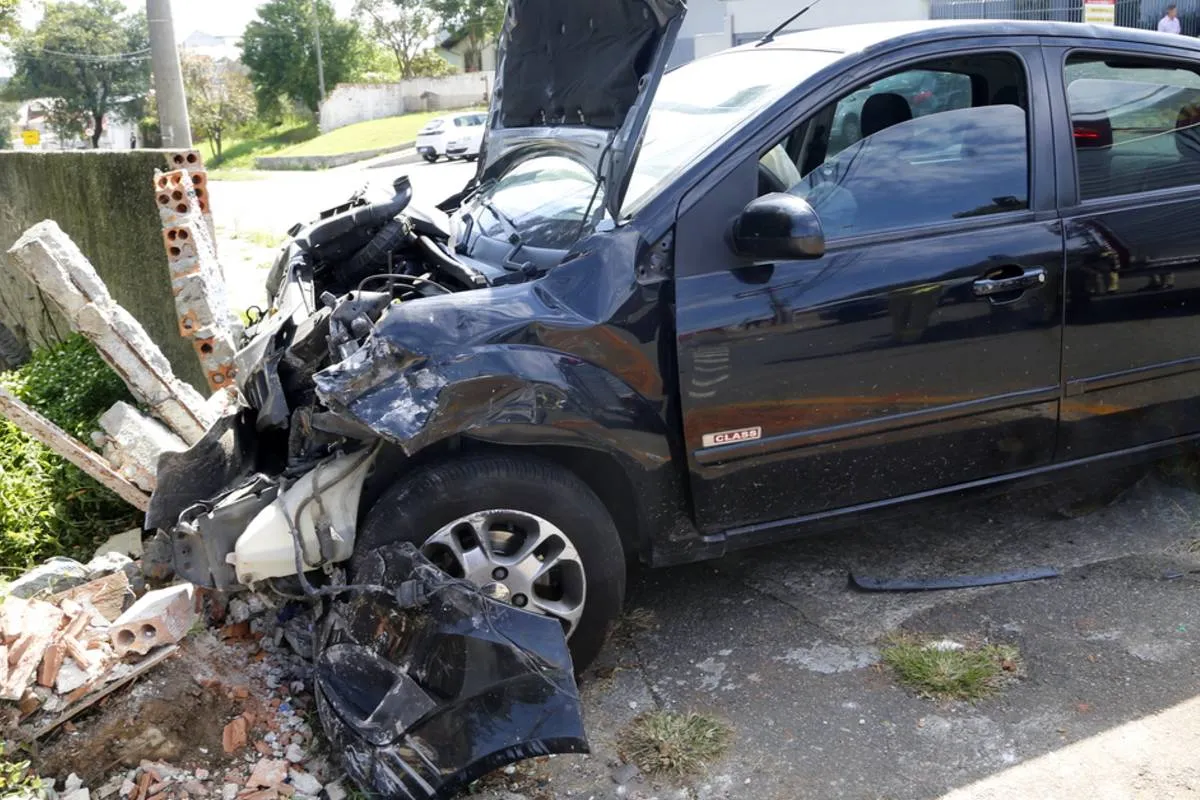Imagem mostra um carro preso envolvido em um acidente de trânsito em Curitiba.