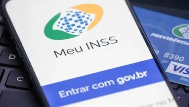 Imagem mostra uma pessoa com o celular aberto no App Meu INSS
