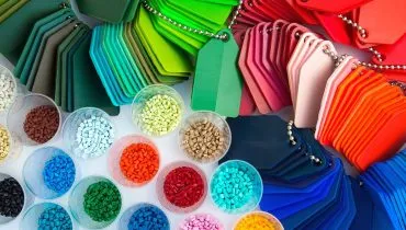 Imagem mostra vários potes com grãos de polietileno, de várias cores, e também lâminas de plástico em vários formatos e cores