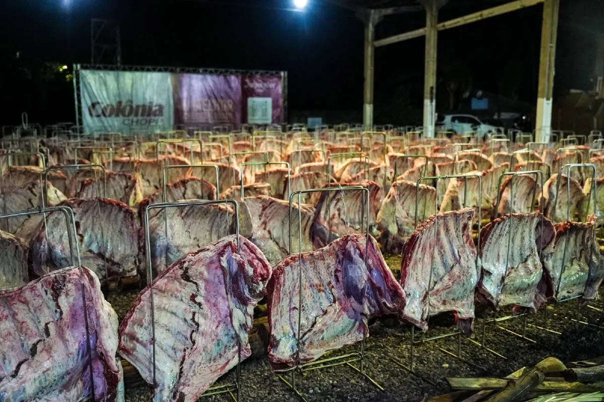 Imagem mostra dezenas de costelas espetadas no chão para um grande churrasco em Cascavel.