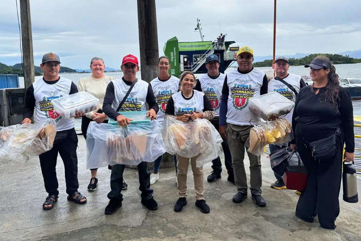Imagem mostra um grupo de ambulantes com camisetas brancas perto de um ferry boat.