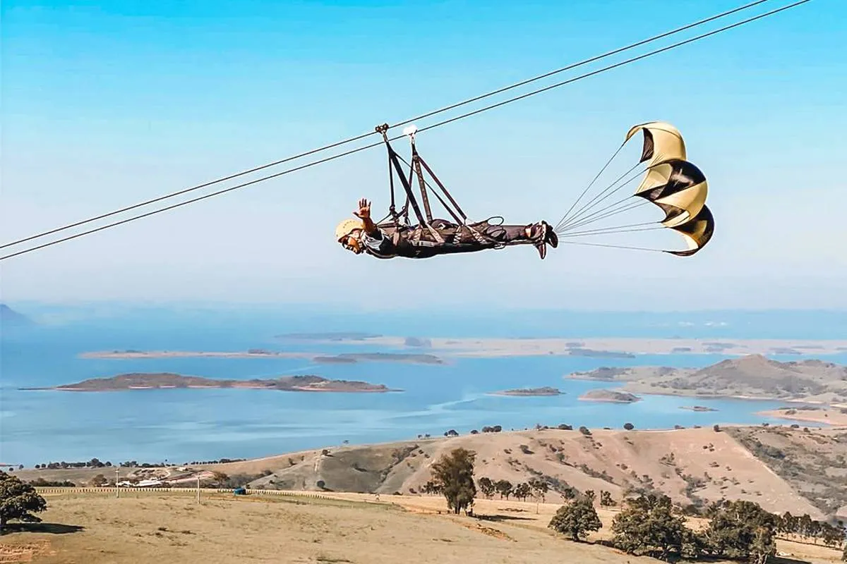 Imagem mostra uma pessoa em uma tirolesa gigante no Paraná.