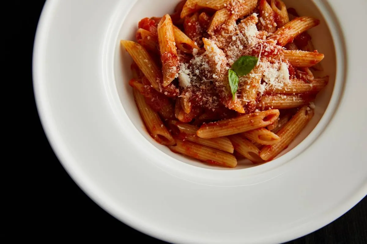 Imagem mostra um prato branco com uma bela macarronada.