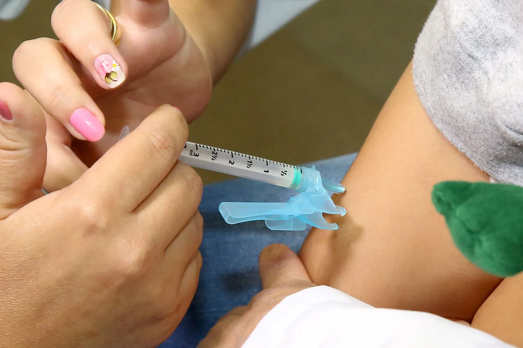 Imagem mostra uma criança sendo vacinada contra a gripe.
