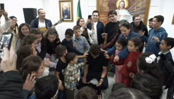Nikolas Ferreira recebe oração de crianças em visita a instituição em Curitiba
