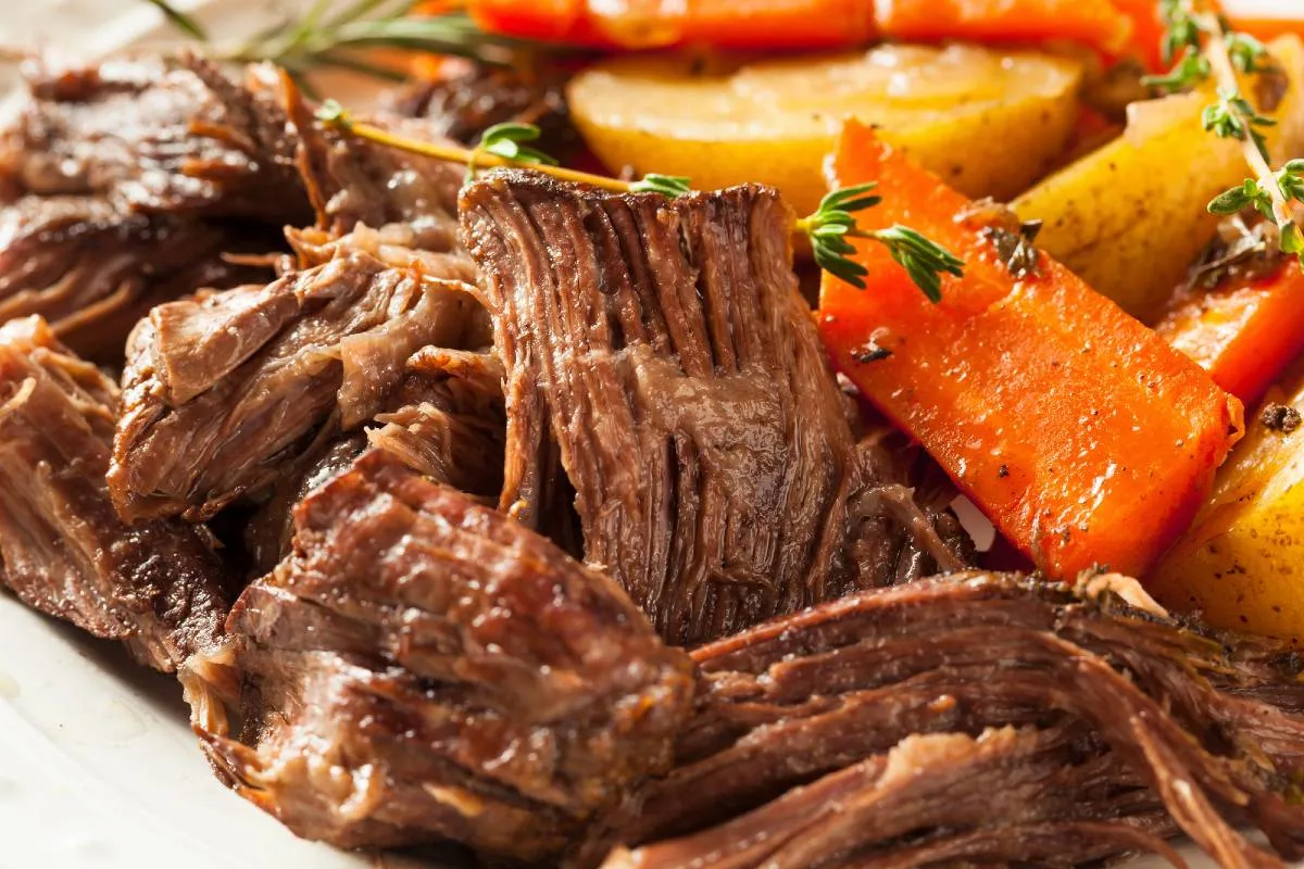 Imagem mostra uma carne na panela de pressão com cenoura e batatas