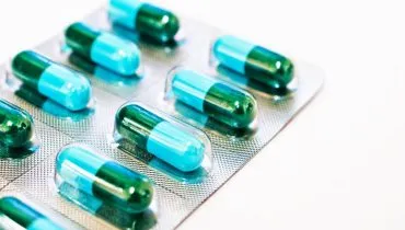 Imagem mostra uma cartela com remédios. Os comprimidos têm duas cores: azul claro e verde escuro.