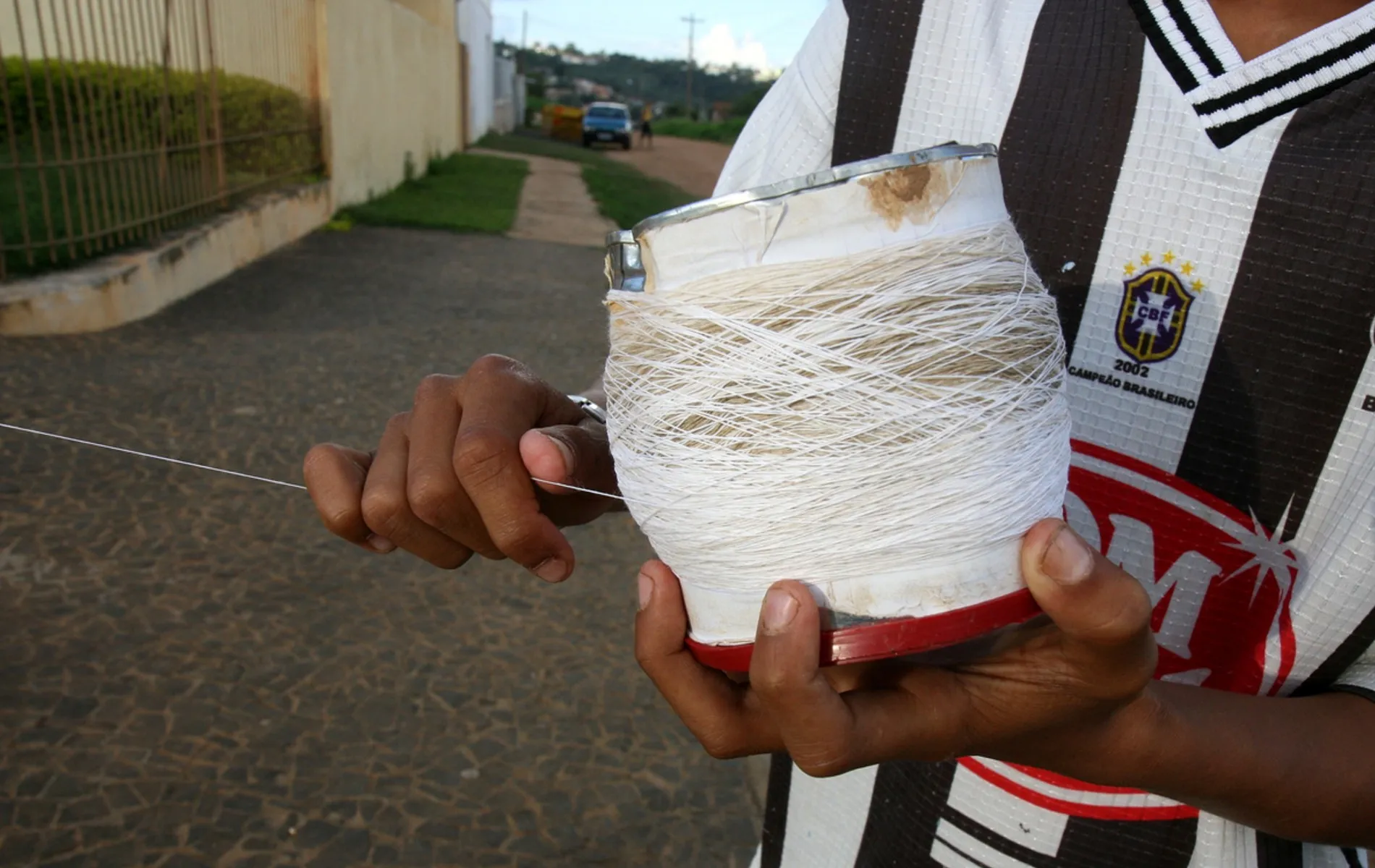 Menino enrola linha para empinar pipa.