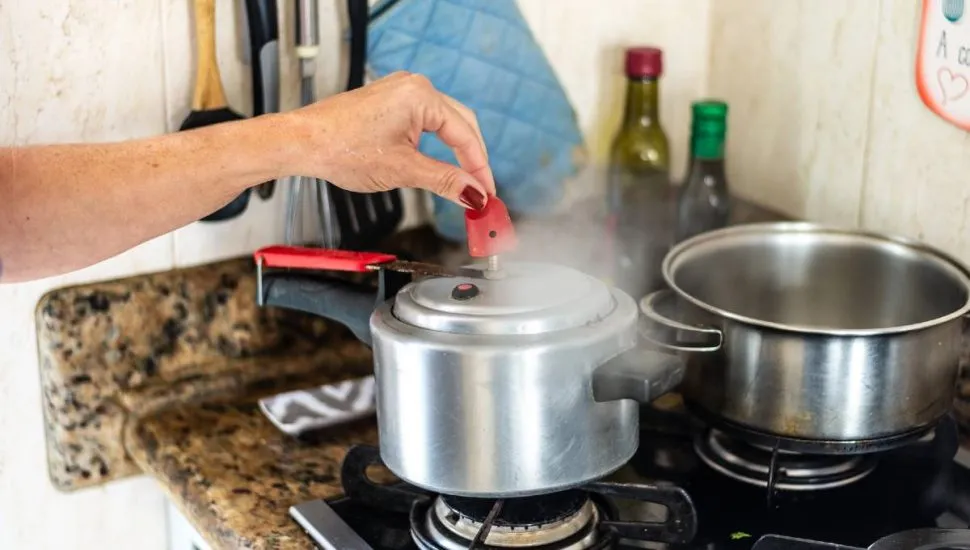 Imagem mostra uma panela de pressão com vapor sendo liberado.
