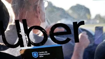 Imagem mostra um motorista de aplicativo dirigindo pela Uber.