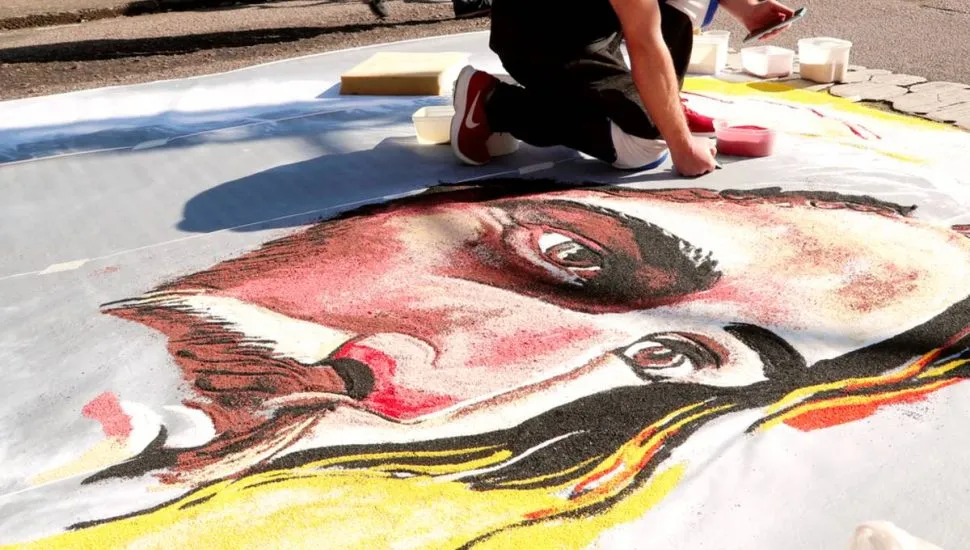 Imagem mostra a confecção de um tapete de Corpus Christi.