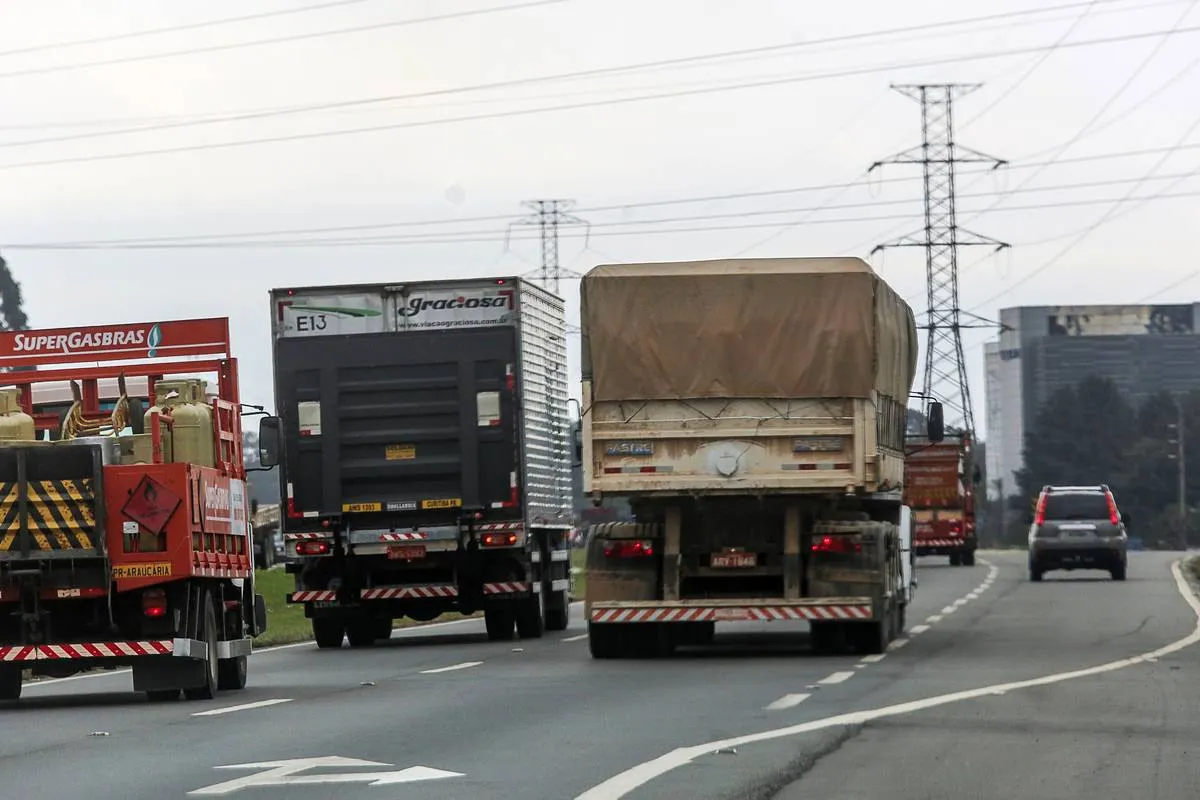Imagem mostra caminhões circulando em uma estrada do Paraná.