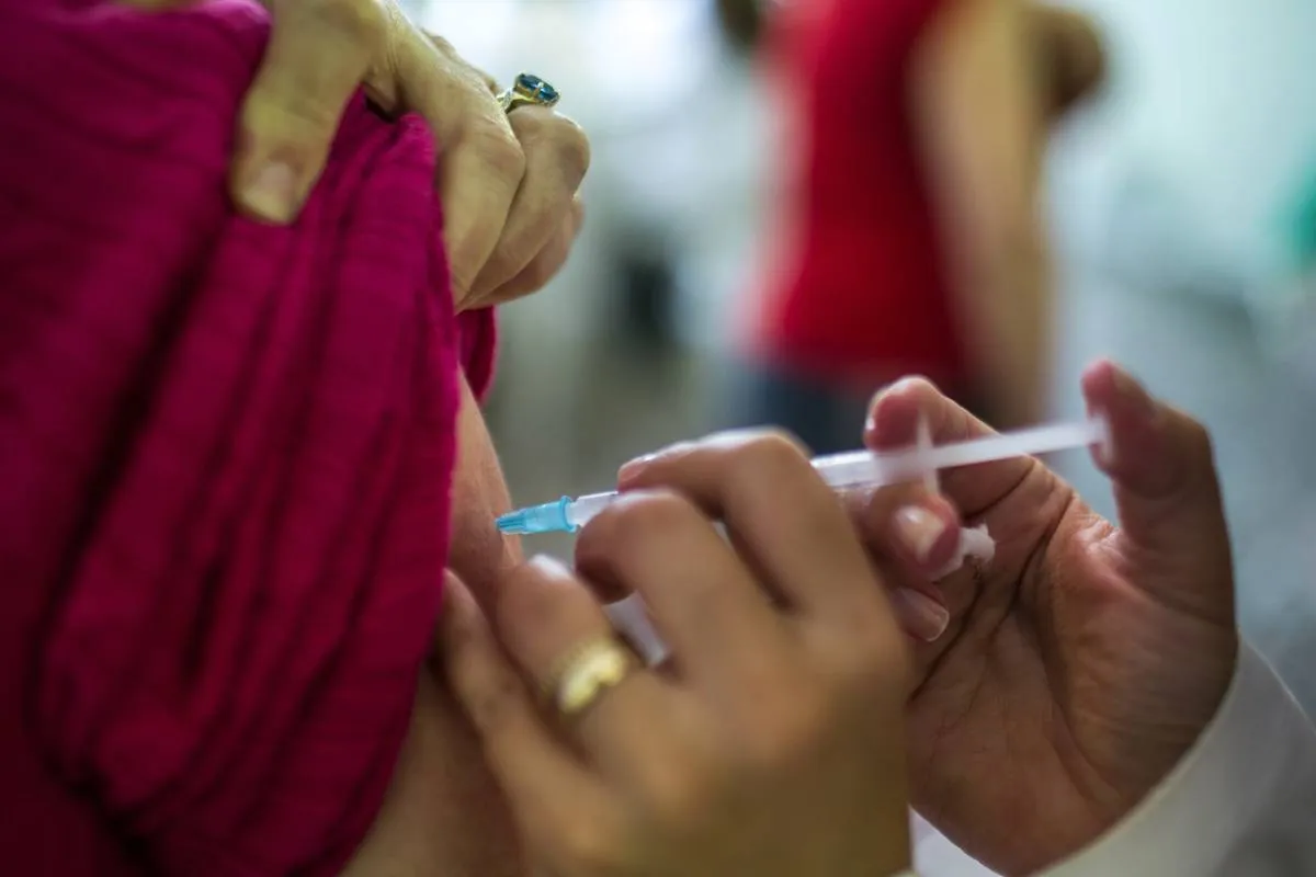 Imagem mostra uma pessoa sendo imunizada com a vacina contra a gripe.