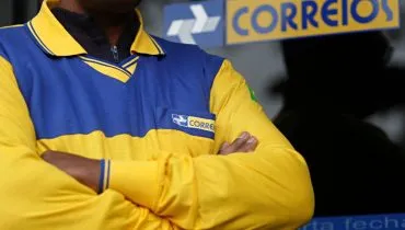 Imagem mostra um trabalhador dos Correios com os braços cruzados.