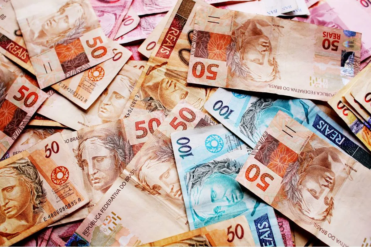 Imagem mostra notas de real em cima de uma mesa.