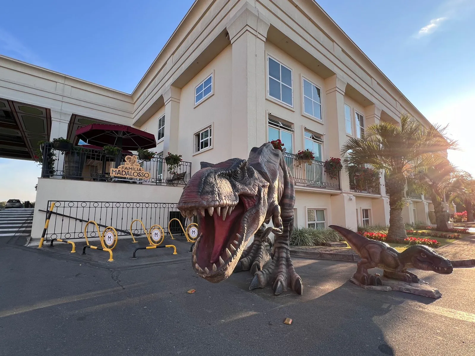 Esculturas gigantes de dinossauros no pátio de restaurante Madalosso