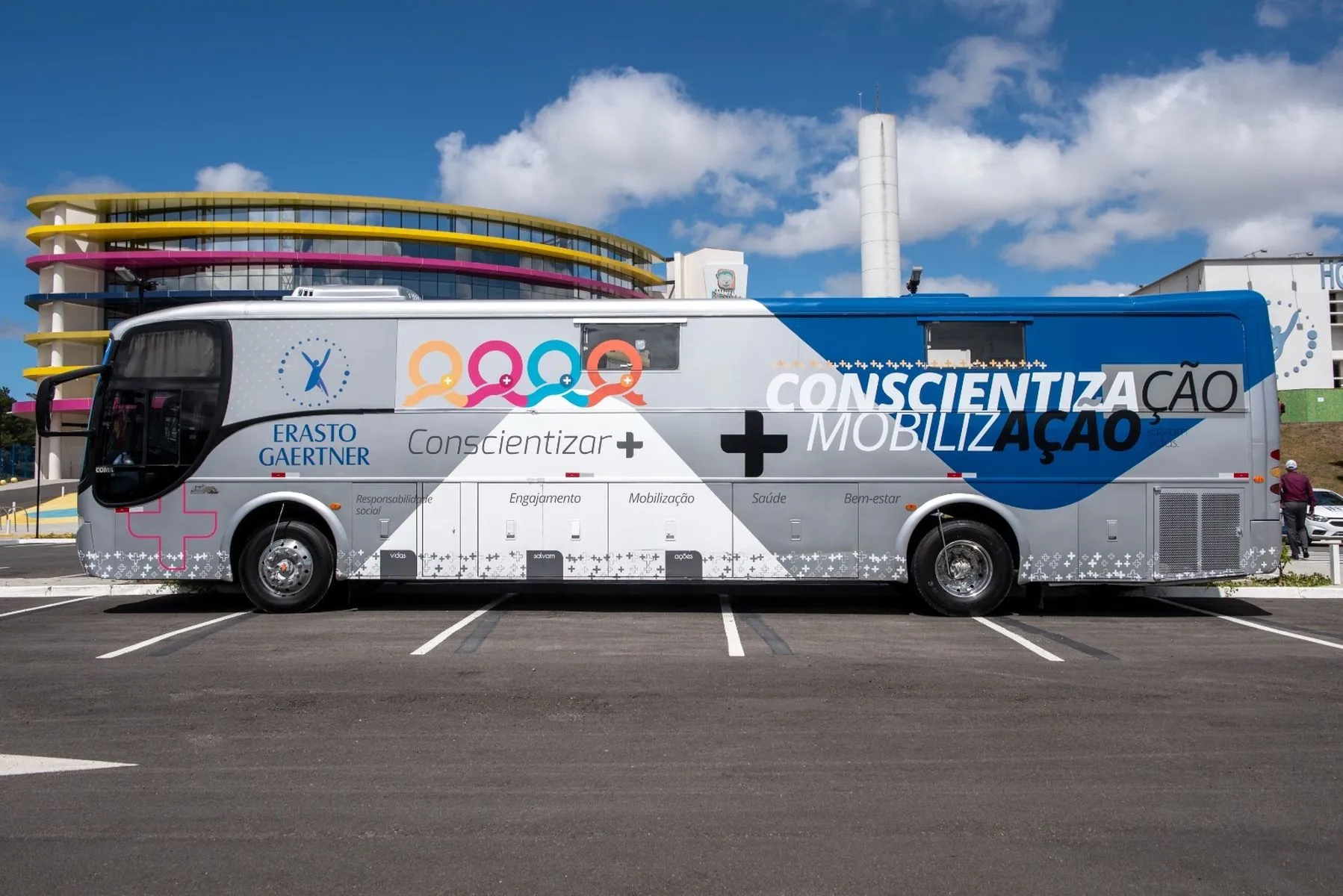 Imagem mostra um Ônibus plotado com imagem de SÃo Francisco de Assis no estacionamento do Hospital Erastinho