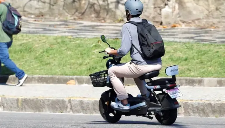 Imagem mostra uma pessoa circulando com uma moto elétrica.