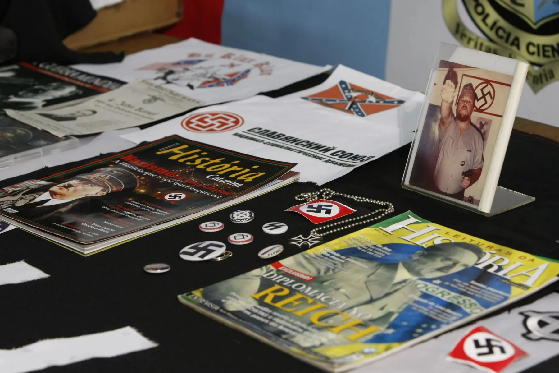 mesa cheia com revistas, fotos e recortes que mostram Hitler e outro símbolos nazistas