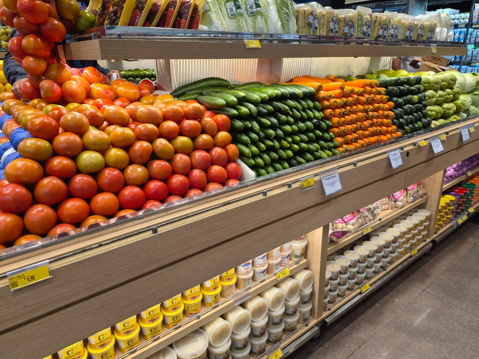 Gôndola com diversos legumes e verduras no no supermercado Muffato Champagnat. Hortifruti, tomate, pepino, cenoura, pimentão e outros produtos.