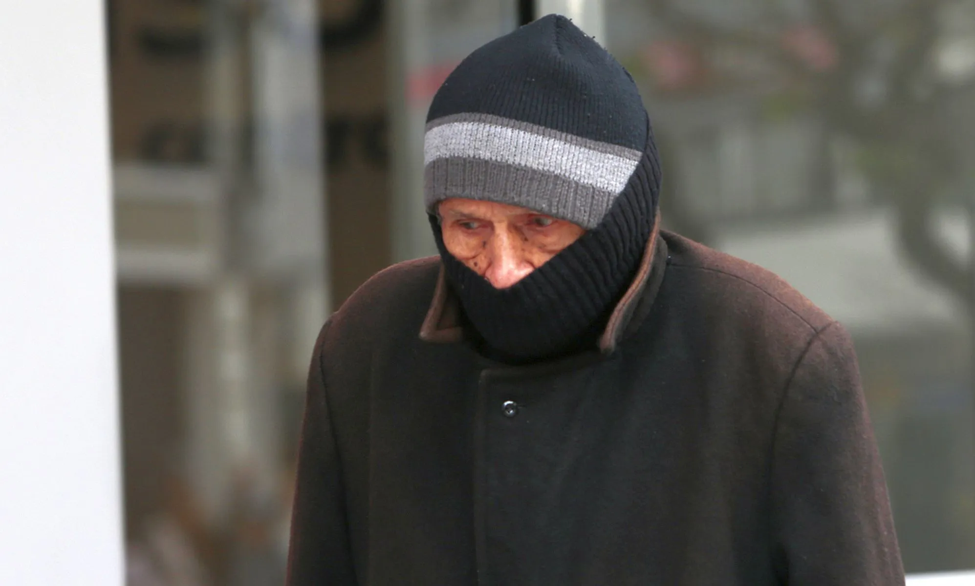 Imagme mostra senhor com roupas de frio e uma toca, com apenas os olhos e o nariz para fora