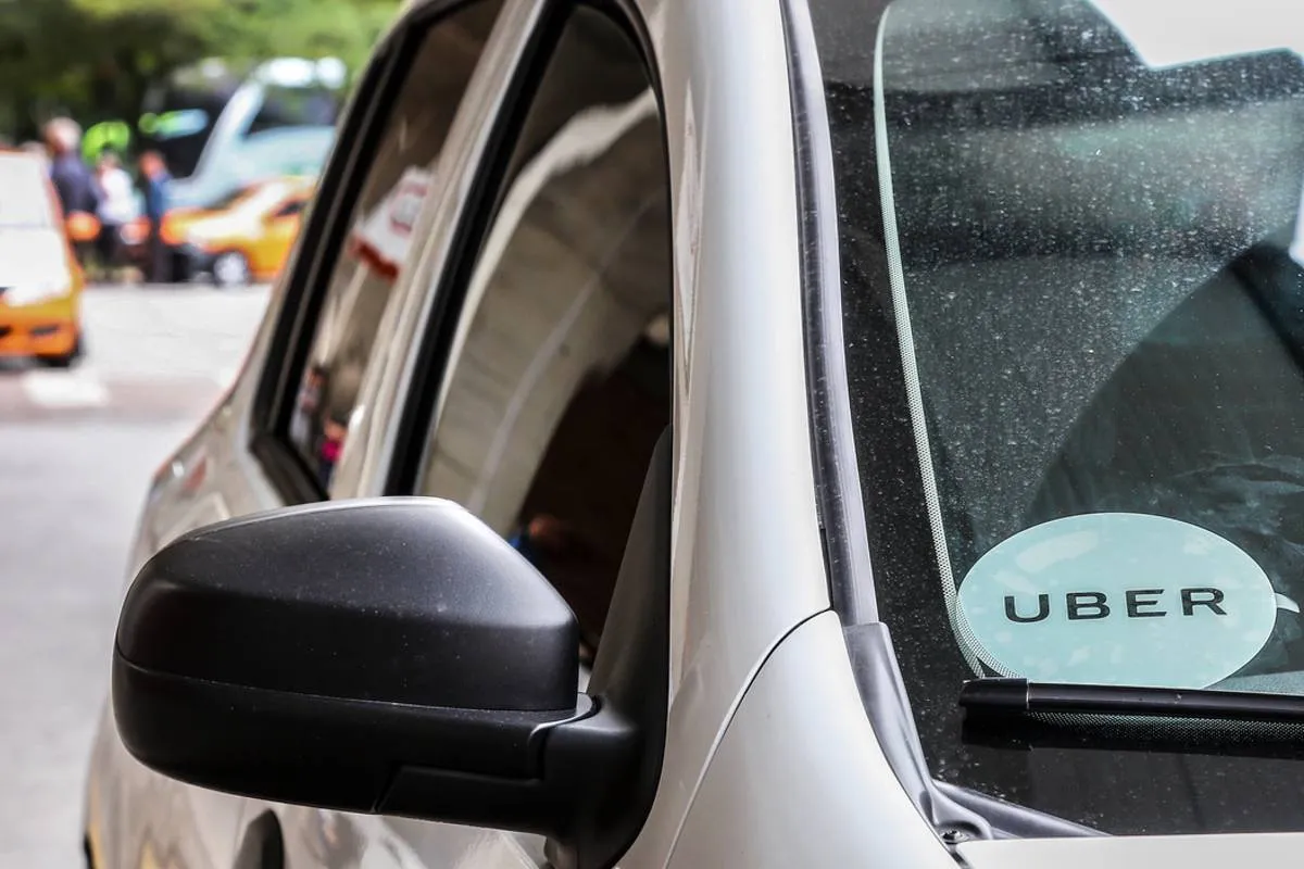 Imagem mostra um carro cinza estacionado na rodoferroviária de Curitiba. O veículo tem um adesivo escrito Uber no canto inferior esquerdo de quem vê.