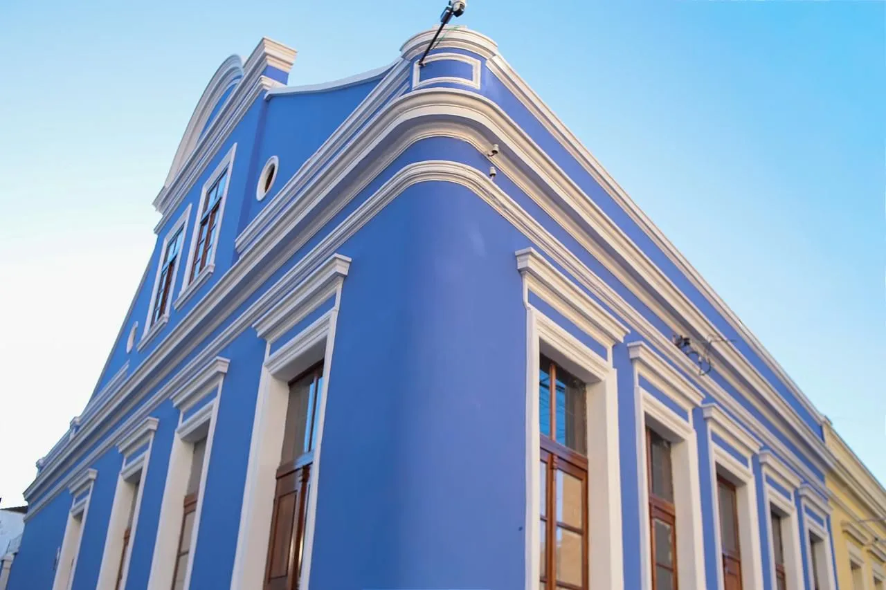Casa antiga restaurada, com fachada azul e janelas brancas. Casa Maleski