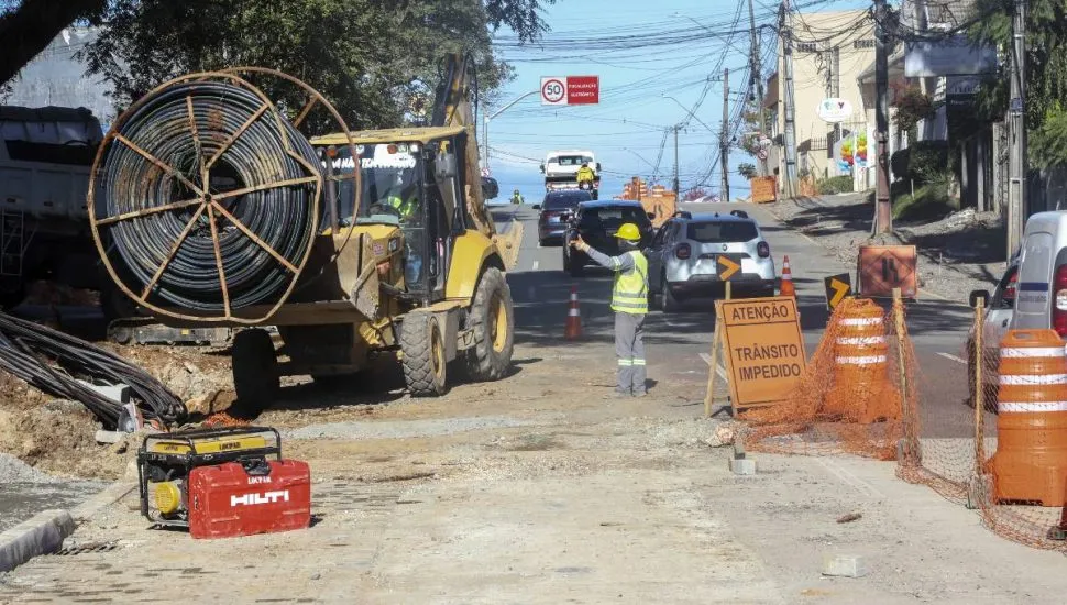 Imagem mostra uma bloqueio no trânsito de Curitiba com máquinas e homens da pista.