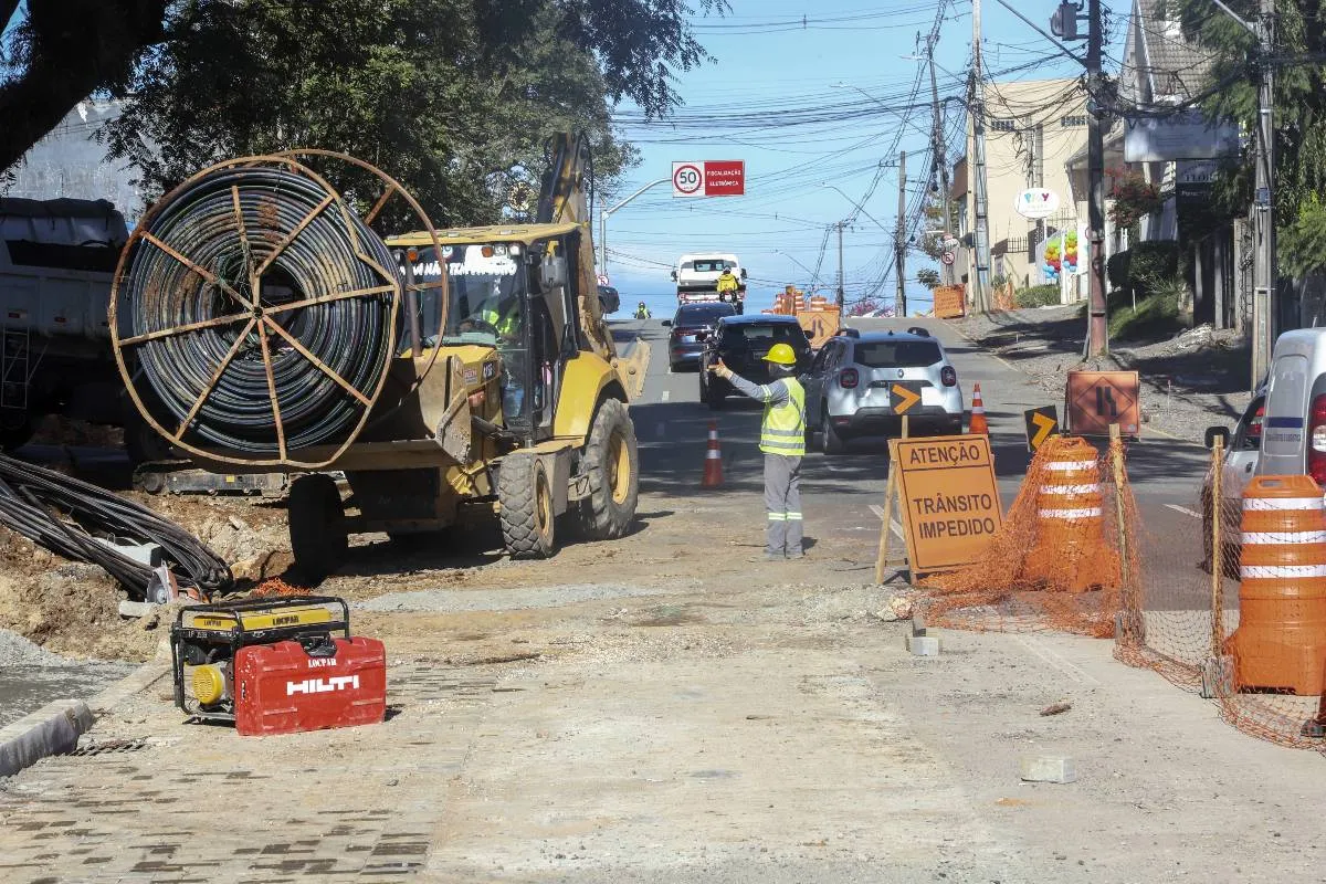 Imagem mostra uma bloqueio no trânsito de Curitiba com máquinas e homens da pista.