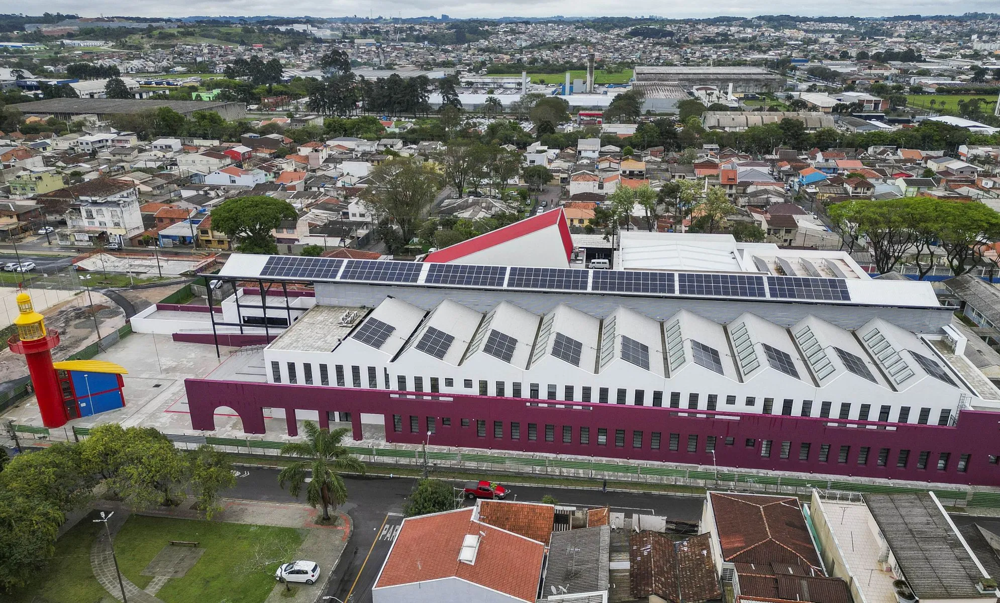 Imagem aérea mostra a Rua da Cidadania do CIC, um Farol do Saber e várias casas da região.