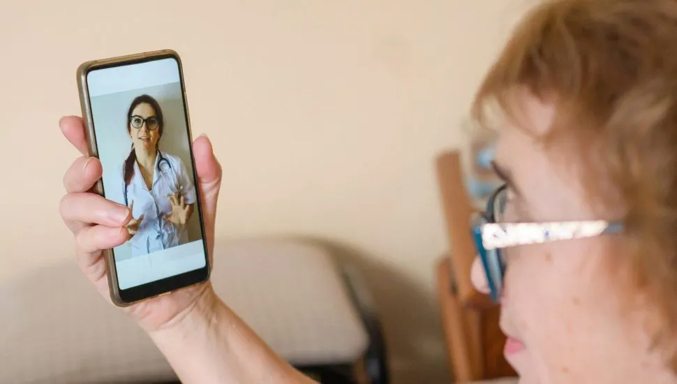 Imagem mostra senhora idosa segurando um smartphone